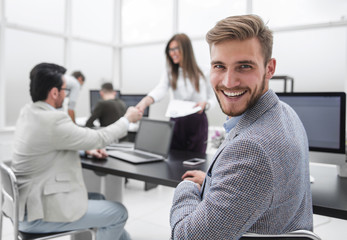 rear view. successful businessman sitting at his Desk