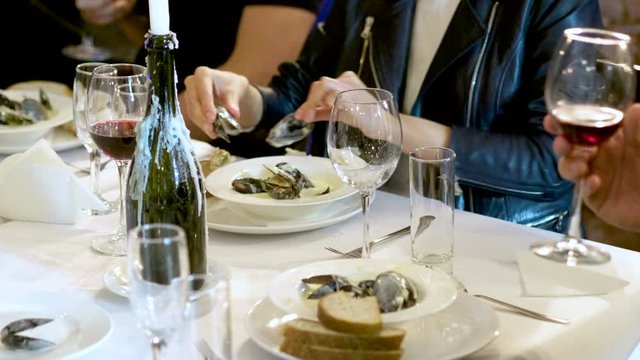 Group of people eating prepared delicious mussels in cream at culinary school. 4K