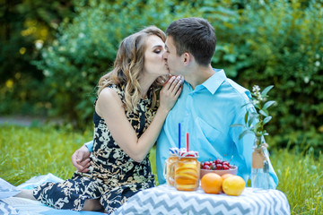 Young loving couple kissing in the park. The concept of love, relationships, family, lifestyle.