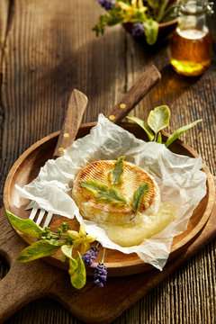 Grilled Camembert cheese with addition aromatic herbs, top view. Vegetarian food, barbecue.