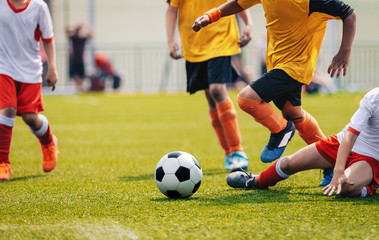 Naklejka na ściany i meble Young Junior Football Match. Players Running and Kicking Football Ball