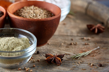 Spices in ceramic bowls on the top of wooden barrel, close-up, selective focus, vertical.