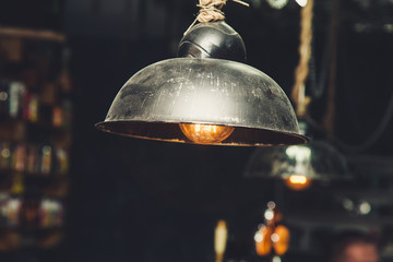 Edison lamp with glowing filament under the lampshade