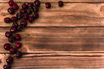 Obraz na płótnie Canvas A bunch of cherries on wooden rustic background with a copy space for text