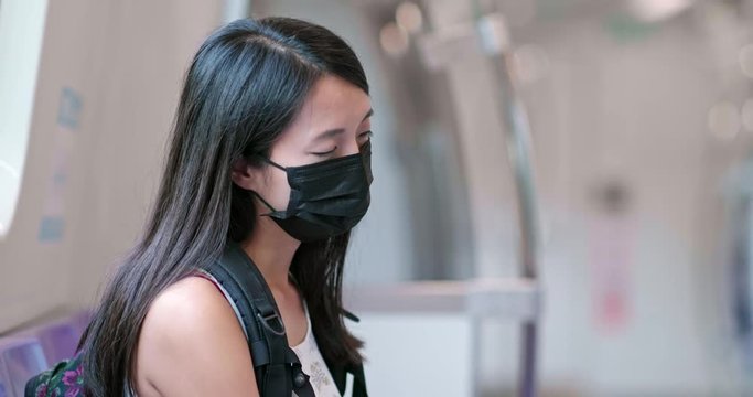 Woman wearing mask and sleep on train