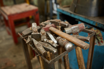 Working metal tools in blacksmith's workshop, close-up, selective focus, nobody