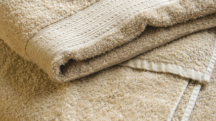 Fototapeta na wymiar Beige Bath Towel. Folded Towel Texture. Bathroom Accessories Background