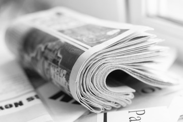 Latest news in daily papers. Folded newspapers stacked in pile. Pages with headlines and articles scattered on table and stack of tabloid journals, selective focus  - obrazy, fototapety, plakaty