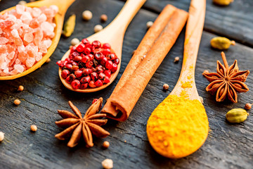 Various colorful herbs and spices in wooden spoons