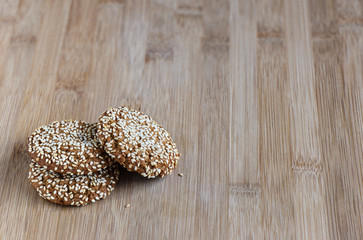 Oatmeal cookies with sesame seeds on a wooden background with sp