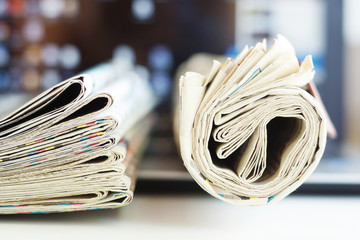 Newspapers and computer. Laptop and daily papers on the table. Fresh news by  paper or by...