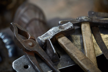 Working metal tools in blacksmith's workshop, close-up, selective focus, nobody
