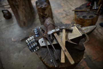 Working metal tools in blacksmith's workshop, close-up, selective focus, nobody