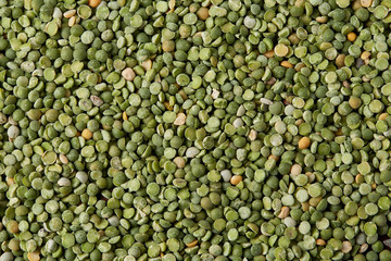 Green peas on rustic wooden background, close-up, top view, selective focus.