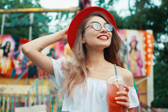 Beautiful young woman holding a drink while smiling