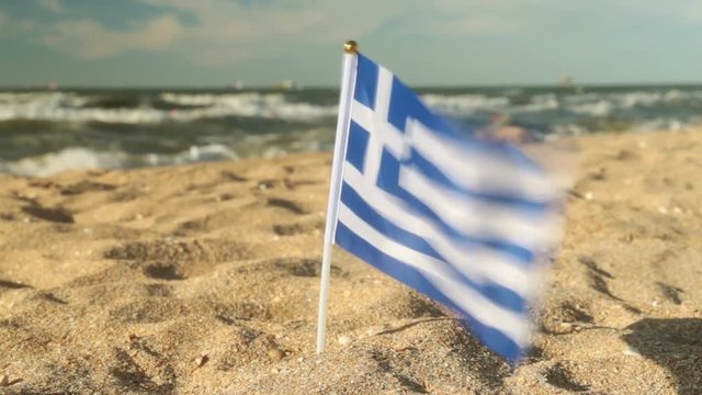 Flag of Greece on a sandy beach.