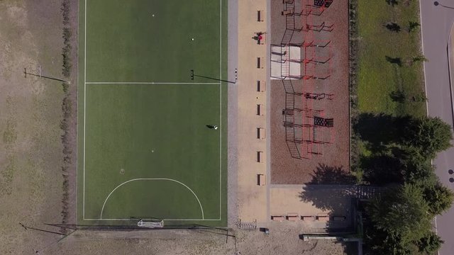 Aerial view. Park with a football field and a training platform. City park with paths and green trees