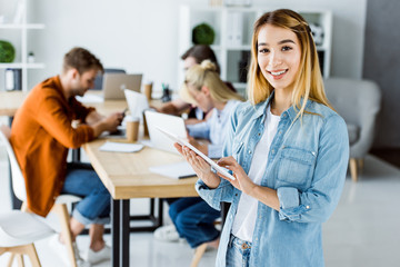 beautiful asian businesswoman standing with tablet in start up office and looking at camera