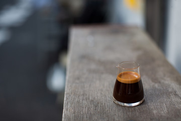 Espresso shot on the wooden table. Summer outdoor cafe. Copy-space for your text.