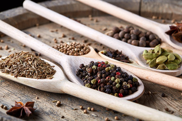 Colourful aromatic various spices for cooking on old wooden board, close-up, flat lay, selective focus.