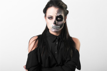 Studio portrait of beauty brunette woman wearing black clothes with scary greasepaint on face standing on white background