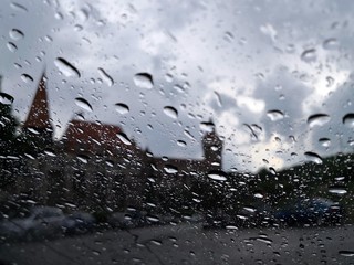 Water drops on window during rain with Hunedoara Castle in the background