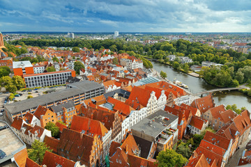 Naklejka premium Old German town of Lubeck on river Trave. Panorama of small town. Medieval Gothic extensive Brick Gothic architecture in Germany. Top veiw. June 2017.