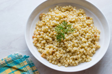 Cooked Couscous with Dill served in White Plate / Turkish Kuskus