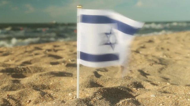 Flag of Israel on a sandy beach.