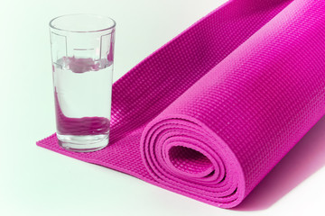 colored mat for fitness, yoga and glass of water