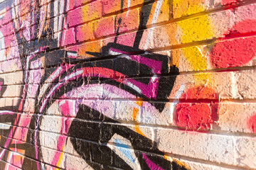 Abstract detail of a graffiti piece on a wall in London, England with bold round curves and light bright colors
