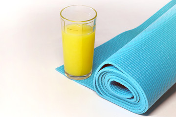mat for fitness, yoga and a glass of orange juice