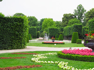 Abstract ideal flower beds and shorn trees in well-kept park