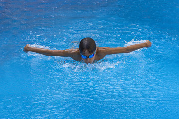 Close up action shot of boy swimming butterfly style.