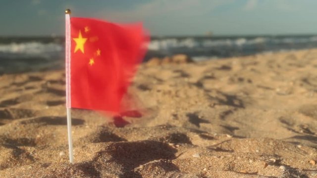 Flag of China on a sandy beach.