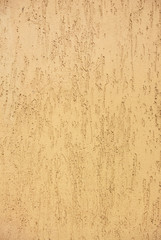 Vertical photo of the yellow colored wall with decorative stucco texture