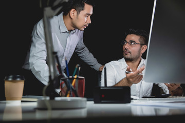 Aasian businessman coworkers discussing work at night