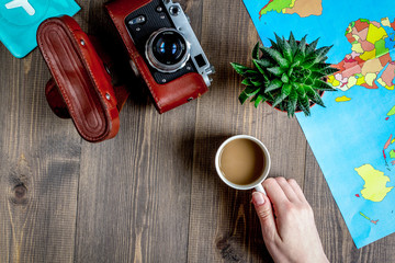 tourist stuff with camera and map on wooden background top view 