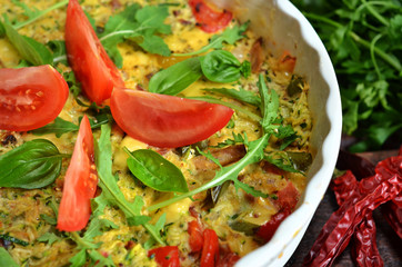 Zucchini casserole with tomatoes and arugula