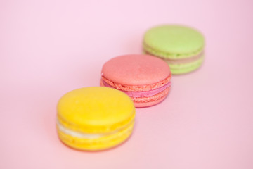 French macaroon biscuits on pastel pink background, beautiful colors