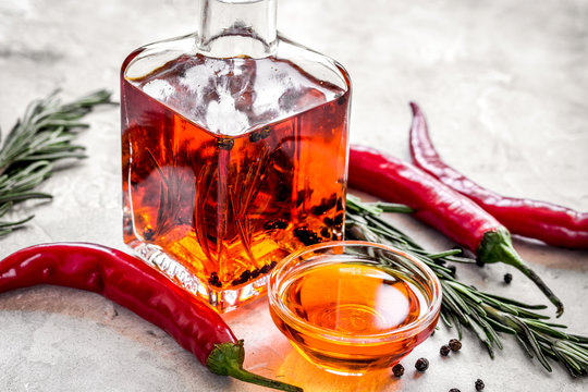 jar with oil and chili on stone table background