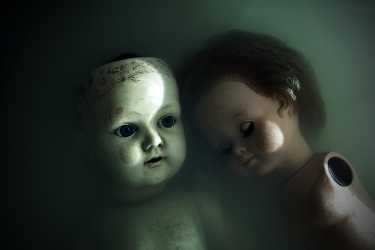 Creepy dolls in dark dirty water 