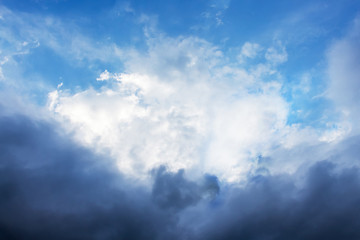 The sky with white clouds surrounded by dark. The sky before the rain_