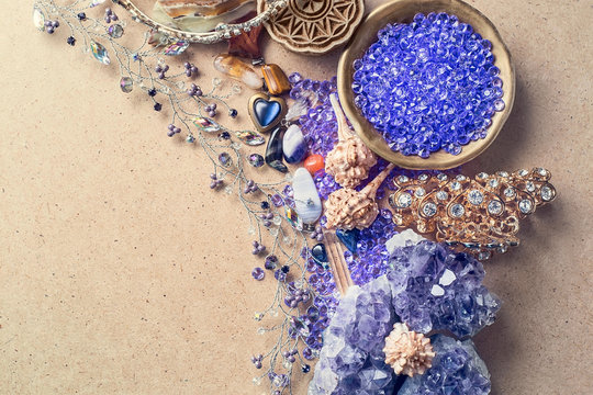 Beautiful stones, crystals, minerals, and other materials on a cardboard textured surface. Magic crystals and products.