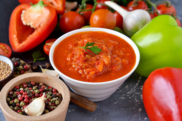 Tomato sauce with vegetables and spices on a black background. Sauce to pizza .Food background.