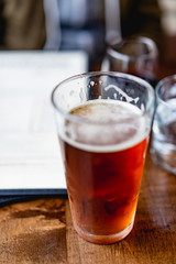 IPA beer next to a window at a rustic bar