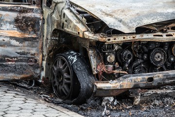 Fototapeta na wymiar Burnt rusty car on road.