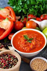 Tomato sauce with vegetables and spices on a black background. Sauce to pizza .Food background.