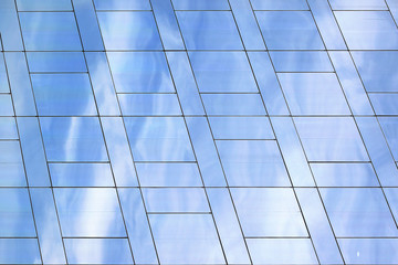 Modern skyscraper glass facade with clouds reflection. Textured background with empty copy space for Editor's text.