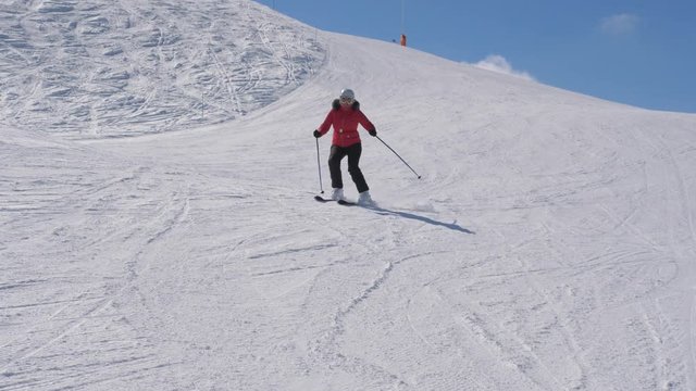 Skier Skiing Down The Slope In The Mountains Carving Turns Splash Snow